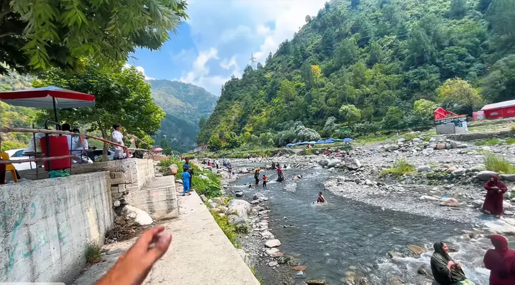 Visitors relaxing on traditional charpai by Harnoi Lake Abbottabad